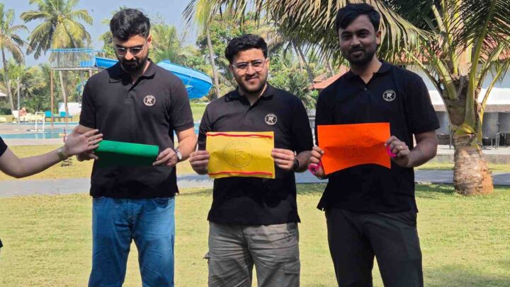 Employees holding creative challenge sheets during an outdoor team event