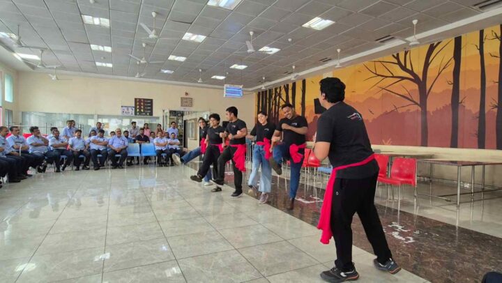 Facilitators conducting an interactive workplace engagement performance for employees during a DimenZion3 session.