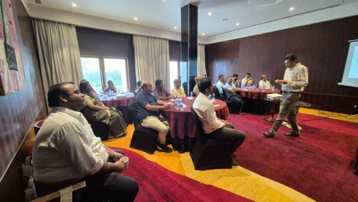 A leadership development facilitator conducting an interactive corporate training session for professionals in a conference room at DimenZion3.
