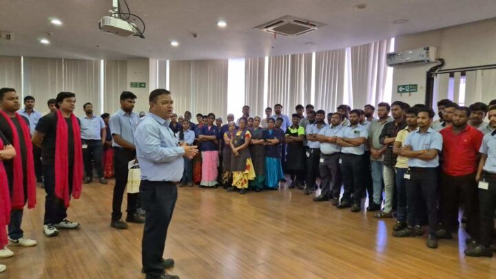A facilitator addressing employees during an organizational development and workplace engagement town hall by DimenZion3.
