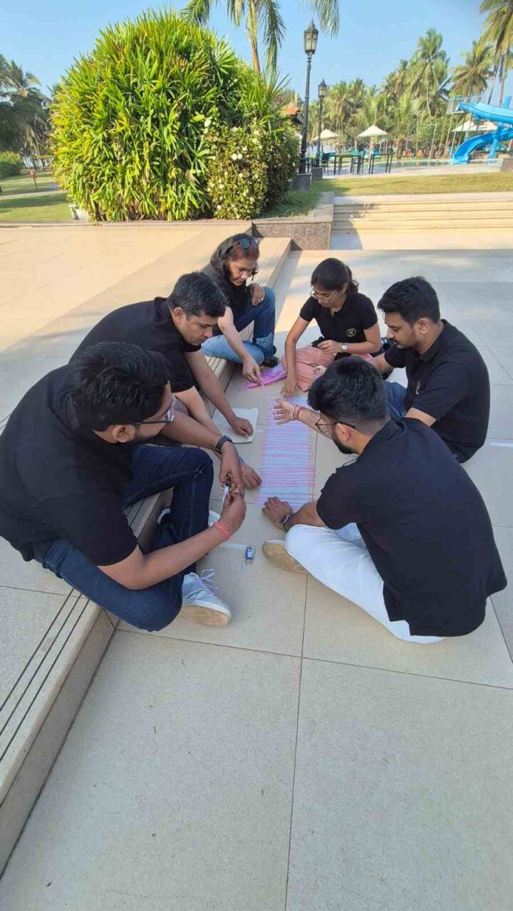 Team members collaborating during an outdoor team building activity facilitated by DimenZion3.