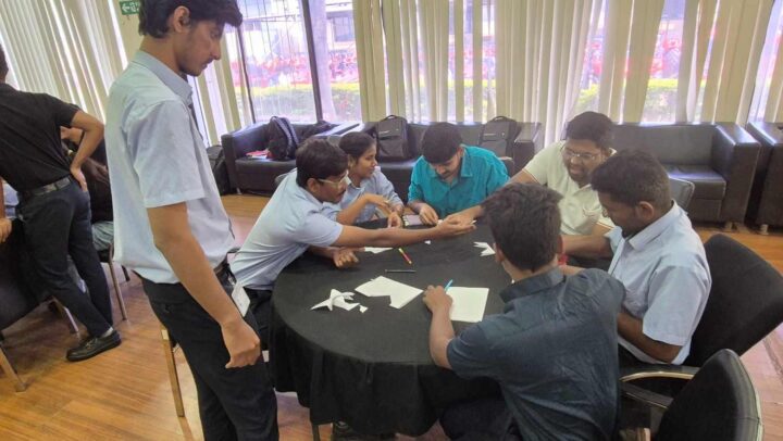 Employees participating in a paper folding team-building activity