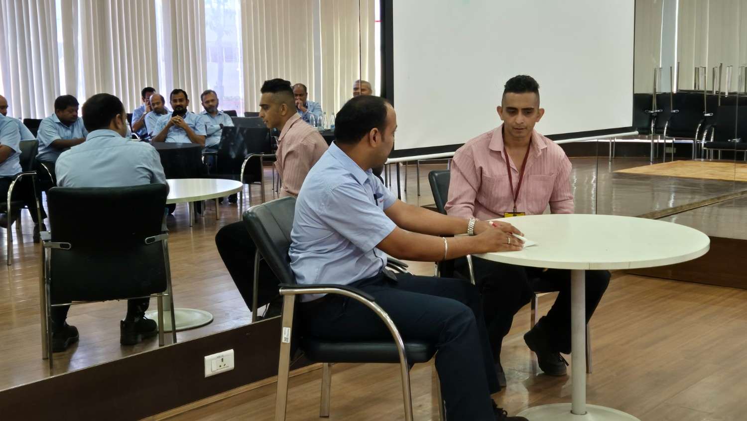 Employees participating in a workplace coaching and paired discussion exercise during a DimenZion3 program.